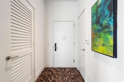 a hallway with a door and a painting on the wall at Discover the Magic of Lyfe Resort and Residences in Hollywood