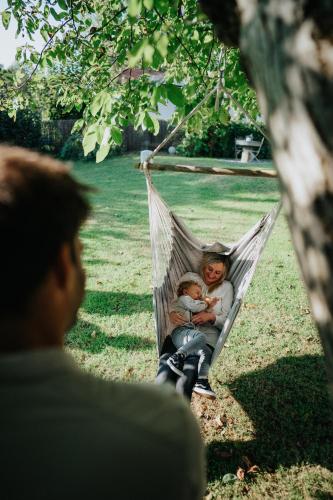 two children sitting in a hammock in a tree at Hotel Leo in Steyr