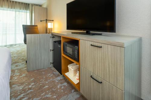 a room with a flat screen tv on a cabinet at Comfort Inn Hwy 401 in Kingston