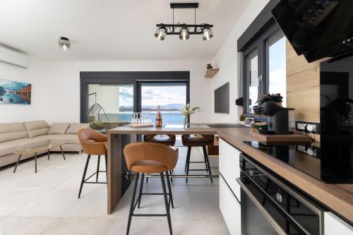 a kitchen and living room with a table and chairs at Cassiopeia - Seaside Retreat in Omišalj