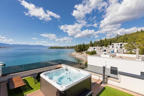 a hot tub on a balcony with a view of the water at Cassiopeia - Seaside Retreat in Omišalj