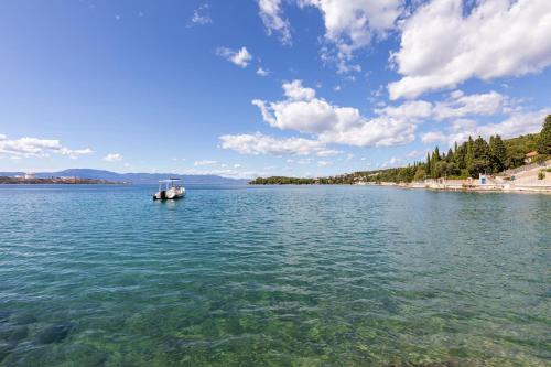 a boat floating on a large body of water at Cassiopeia - Seaside Retreat in Omišalj