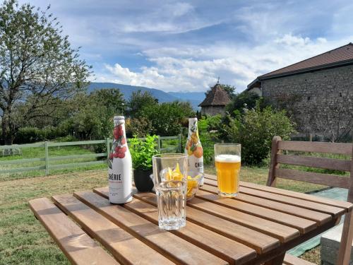 - une table en bois avec 2 bouteilles et des verres de bière dans l'établissement Le Lodge Merlin Studio 2 personnes, à Barraux