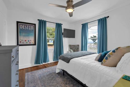 a bedroom with a white bed and blue curtains at Retro by the Bay Close to Beach Eglin PetFriendly in Freeport