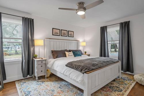 a bedroom with a white bed and two windows at Retro by the Bay Close to Beach Eglin PetFriendly in Freeport