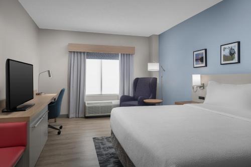 a hotel room with a bed and a desk and a television at Hilton Garden Inn Wilkes-Barre in Wilkes-Barre