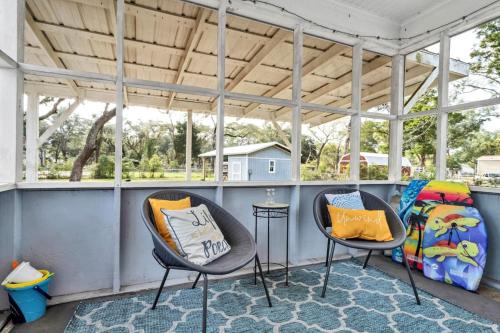 a porch with two chairs and a table at Retro by the Bay Close to Beach Eglin PetFriendly in Freeport