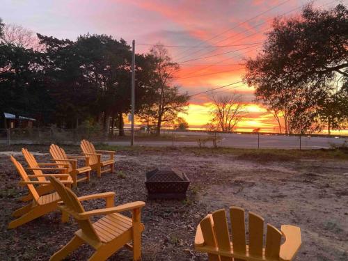 a group of chairs sitting in a park at sunset at Retro by the Bay Close to Beach Eglin PetFriendly in Freeport