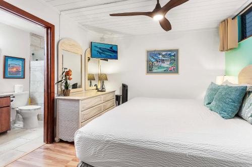 a bedroom with a white bed and a bathroom at Kona Reef A36 in Kailua-Kona