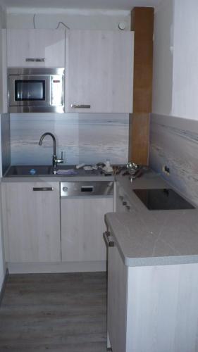 a kitchen with a sink and a microwave at Haus Panorama in Lermoos
