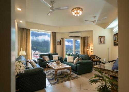a living room with couches and a table at Aarohan by Ganga kripa in Narendranagar