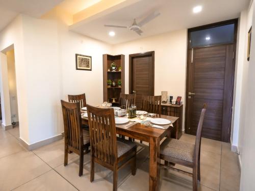 a dining room with a wooden table and chairs at Aarohan by Ganga kripa in Narendranagar