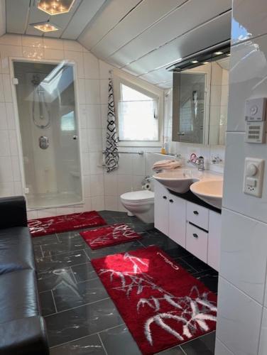 a bathroom with two sinks a toilet and a shower at Ruhige Zimmer im Grünen und Studio im Naherholungsgebiet in Sigigen