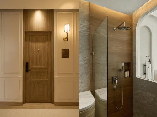 a bathroom with a toilet and a glass shower at Arco Phuket Town in Phuket Town