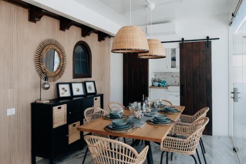 a dining room with a wooden table and chairs at BlueAttic La Mareta in La Mareta