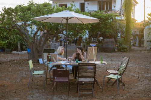 a woman sitting at a table under an umbrella at Vuelve al Origen - Nómadas Digitales in Tegueste