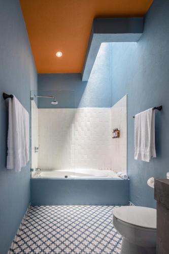 a blue bathroom with a tub and a toilet at HOLT Art Deco Retreat in Vibrant 3 Bedroom Villa in San Miguel de Allende