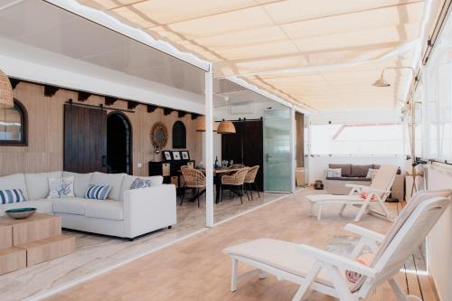 a living room with a white couch and chairs at BlueAttic La Mareta in La Mareta