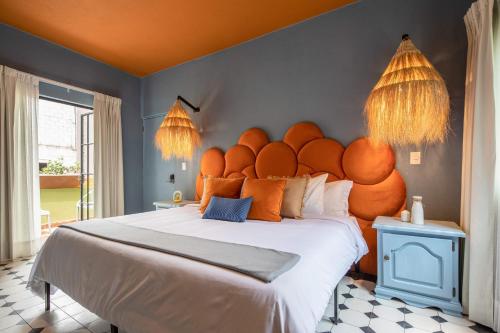 a bedroom with a large bed with an orange headboard at HOLT Art Deco Retreat in Vibrant 3 Bedroom Villa in San Miguel de Allende