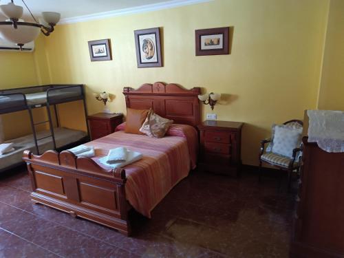 a bedroom with a large wooden bed and two chairs at Casa Rural Chalet Venta del Aire Cortijo Terron in Lanjarón