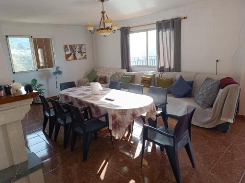 a living room with a table and chairs and a couch at Casa Rural Chalet Venta del Aire Cortijo Terron in Lanjarón