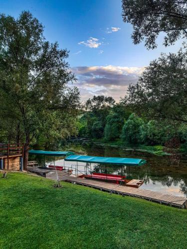 a boat dock with blue roofs next to a river at Holiday House Maya in Mostar