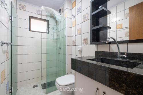 a bathroom with a glass shower and a sink at Apto em otima localização em Meia Praia EIO6031 in Meia Praia