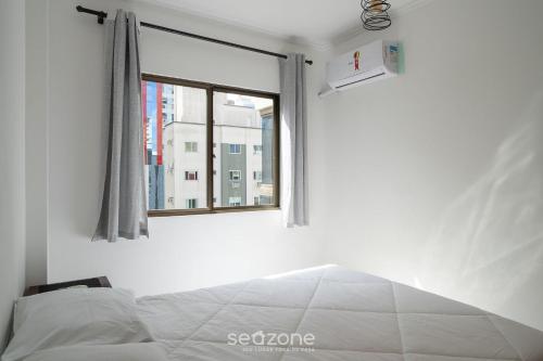 a bedroom with a bed and a window at Apto em otima localização em Meia Praia EIO6031 in Meia Praia