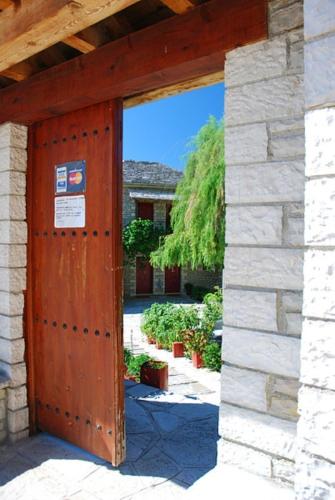 an open wooden door in a brick building at Hotel Ladias in Monodendri