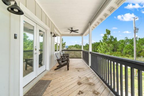 a porch with a rocking chair and windows at Beach Please in Gulf Shores