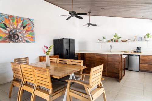 a kitchen and dining room with a wooden table and chairs at Hotel Por Que No? in Uvita