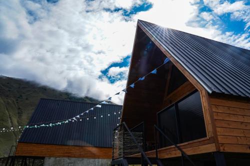 a house with a string of flags on it at Rest point cottage Kazbegi in Stepantsminda