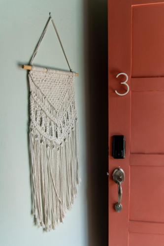 a white fringe bag hanging next to a door at Hotel Por Que No? in Uvita
