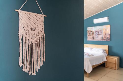 a bedroom with a bed and a hanging fringe curtain at Hotel Por Que No? in Uvita