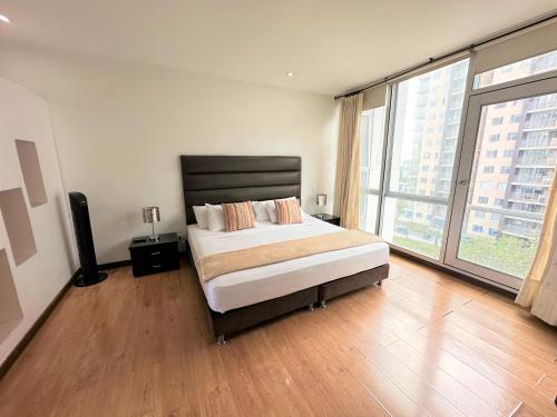 a bedroom with a bed and a large window at M402- Apartaestudio tipo loft en el norte (Av 19) in Armenia