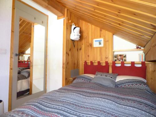 une chambre avec un lit avec une tête de lit rouge dans l'établissement Résidence La Vizelle - Appartement 4 pièces cabine 6 personnes situé à Meribel altitude 1600 proche des pistes et des commerces MAE-8961, à Les Allues