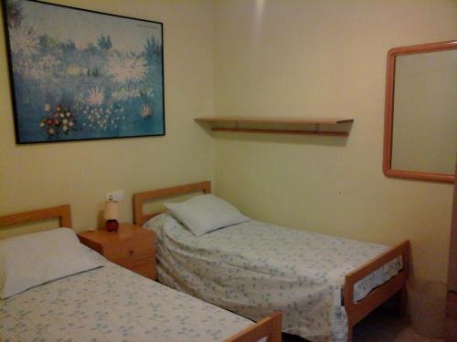 een kamer met twee bedden en een foto aan de muur bij Apartament Fira in Hospitalet de Llobregat