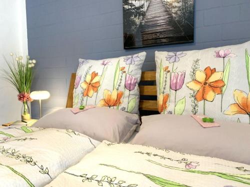 two beds in a room with flowers on the walls at Apartment Kleine Auszeit Eifel in Udler