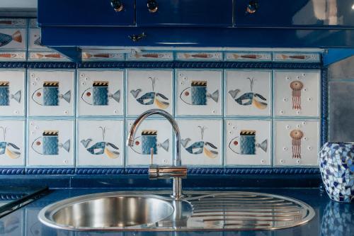 a kitchen sink with a blue and white tiled wall at BlueAttic La Mareta in La Mareta