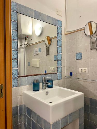 a white sink in a bathroom with a mirror at Il Cortiletto di Ortigia in Syracuse