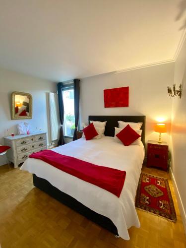 une chambre avec un grand lit blanc avec des oreillers rouges dans l'établissement Appartement avec terrasse, à Paris