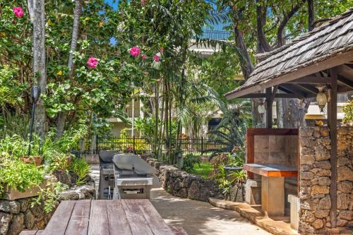 a garden with a wooden table and a bench at Prince Kuhio 110 in Koloa