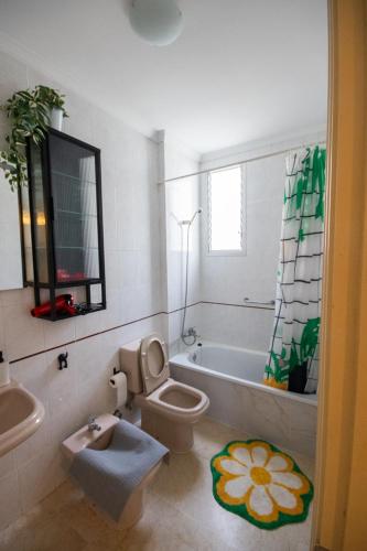 a bathroom with a toilet and a tub and a sink at Casa azul Agaete in Las Palmas de Gran Canaria