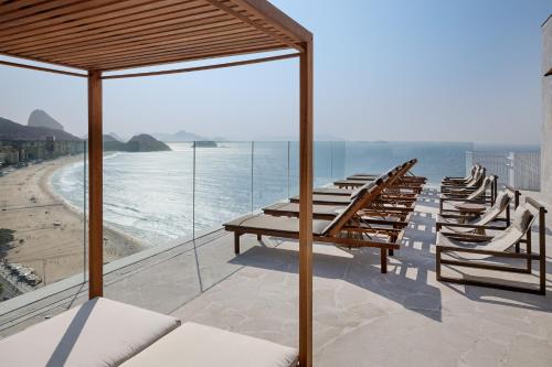a row of chairs on a balcony overlooking the beach at Rio Othon Palace in Rio de Janeiro