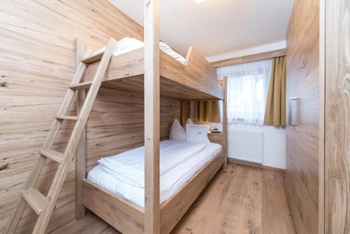 Etagenbett in einem Zimmer mit einer Leiter in der Unterkunft Appartement Landhaus KERSCHDORFER in Kaltenbach