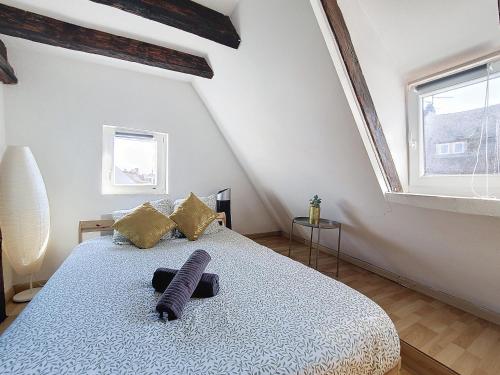 une chambre avec un grand lit avec une grande fenêtre dans l'établissement TONNEAU - Hypercentre - Cathédrale - Authentique - Duplex, à Strasbourg