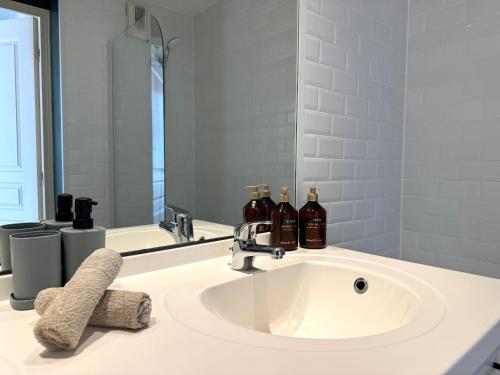 - un lavabo dans la salle de bains avec 3 bouteilles de vin dans l'établissement Le tête dOr, BNBConciergerie, à Villeurbanne