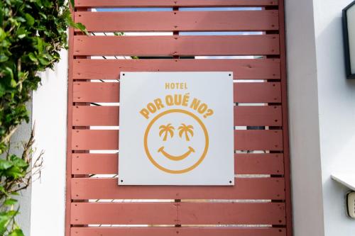 un panneau sur la porte d'une maison dans l'établissement Hotel Por Qué No, à Uvita