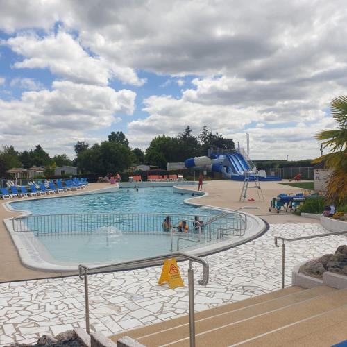 une grande piscine avec un toboggan aquatique dans l'établissement Nat & Mayou, à Onzain