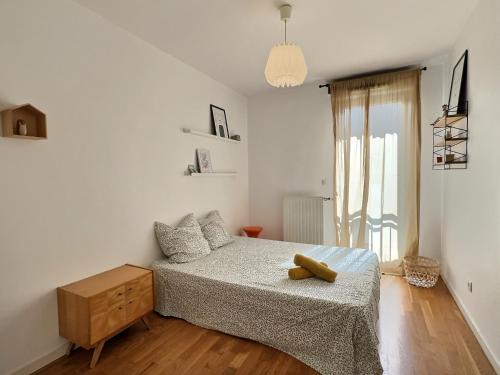 une chambre blanche avec un lit et un parquet dans l'établissement Le tête dOr, BNBConciergerie, à Villeurbanne